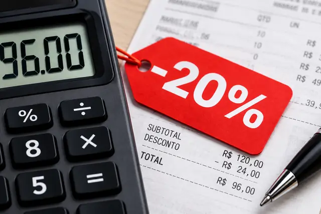 Calculadora de mesa ao lado de uma etiqueta vermelha de desconto